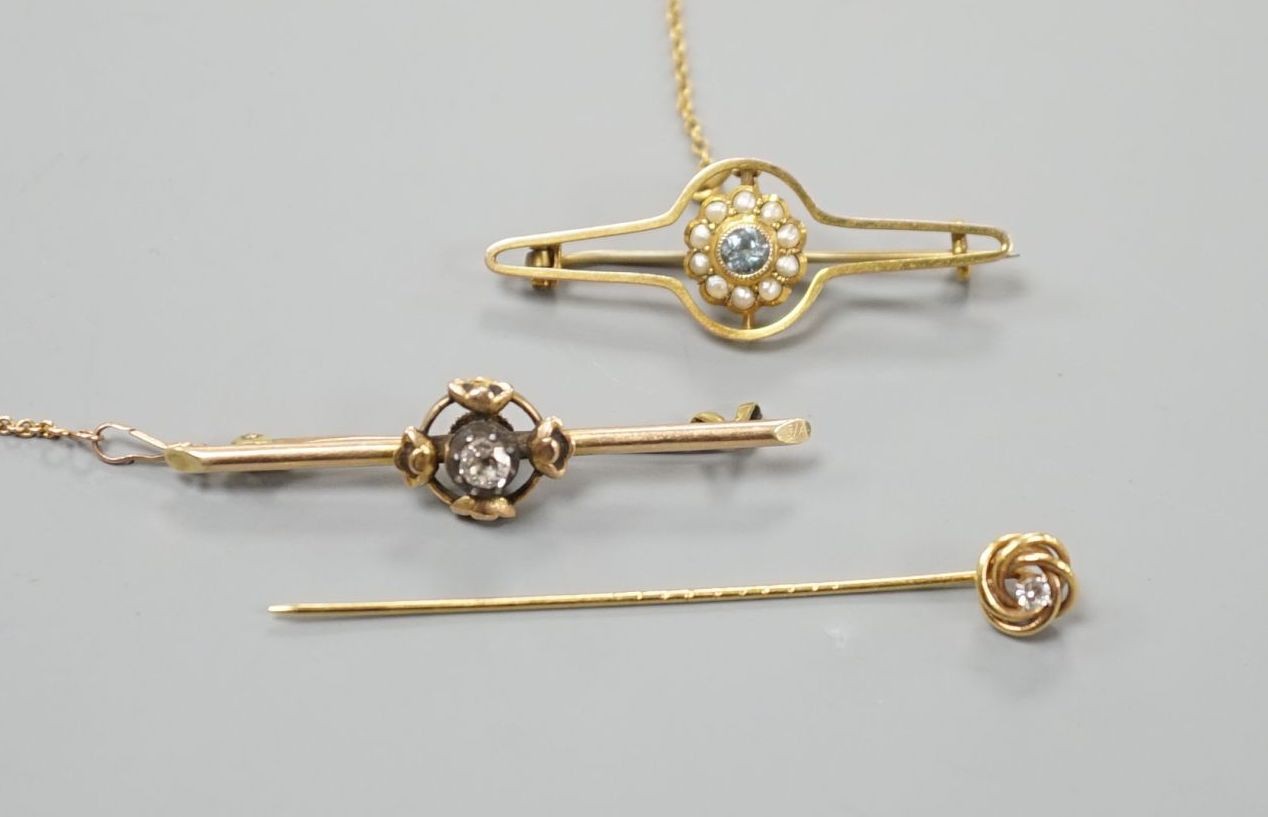 An early 20th century yellow metal and single stone diamond set bar brooch, 46mm, one other gem set bar brooch and a diamond set stick pin, gross weight 6.5 grams.